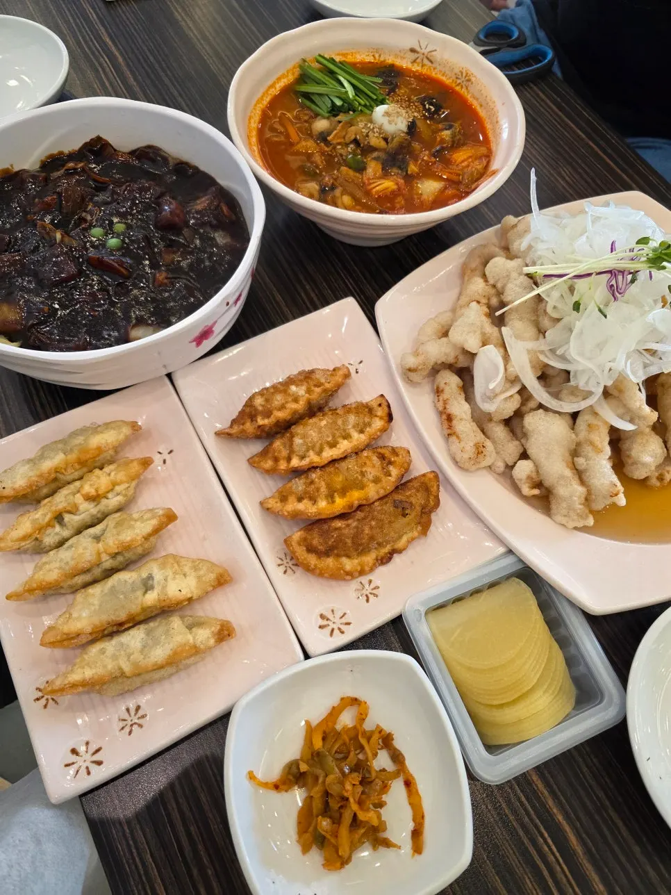 Table set with jjamppong, jjajangmyeon, tangsuyuk, and fried dumplings