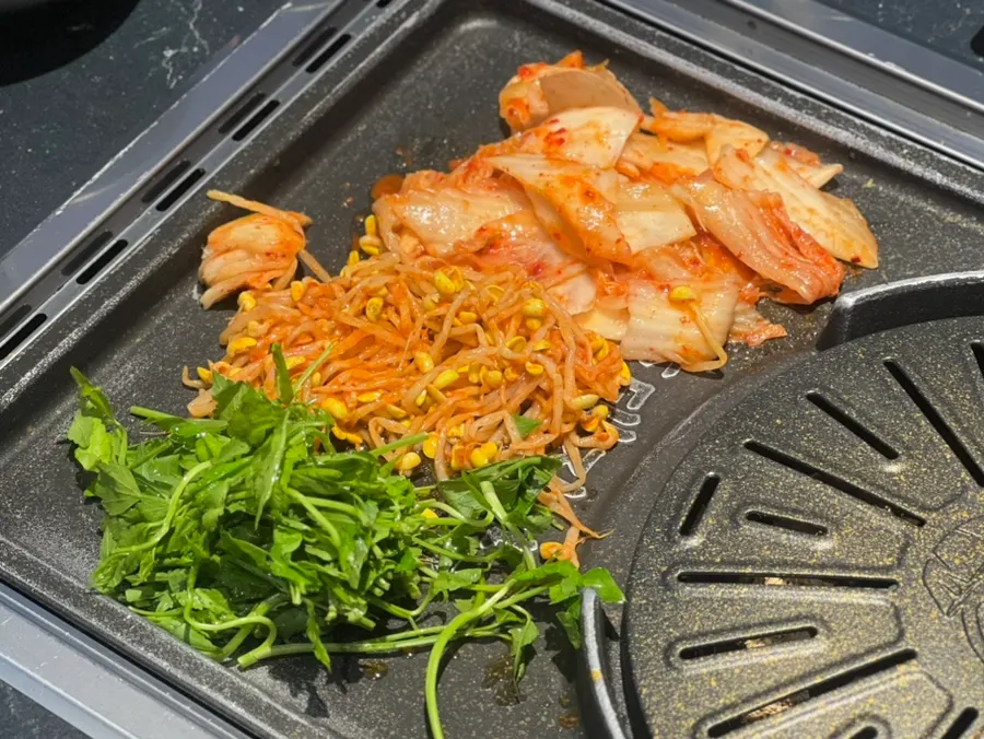 Kimchi, bean sprouts, and minari on the grill
