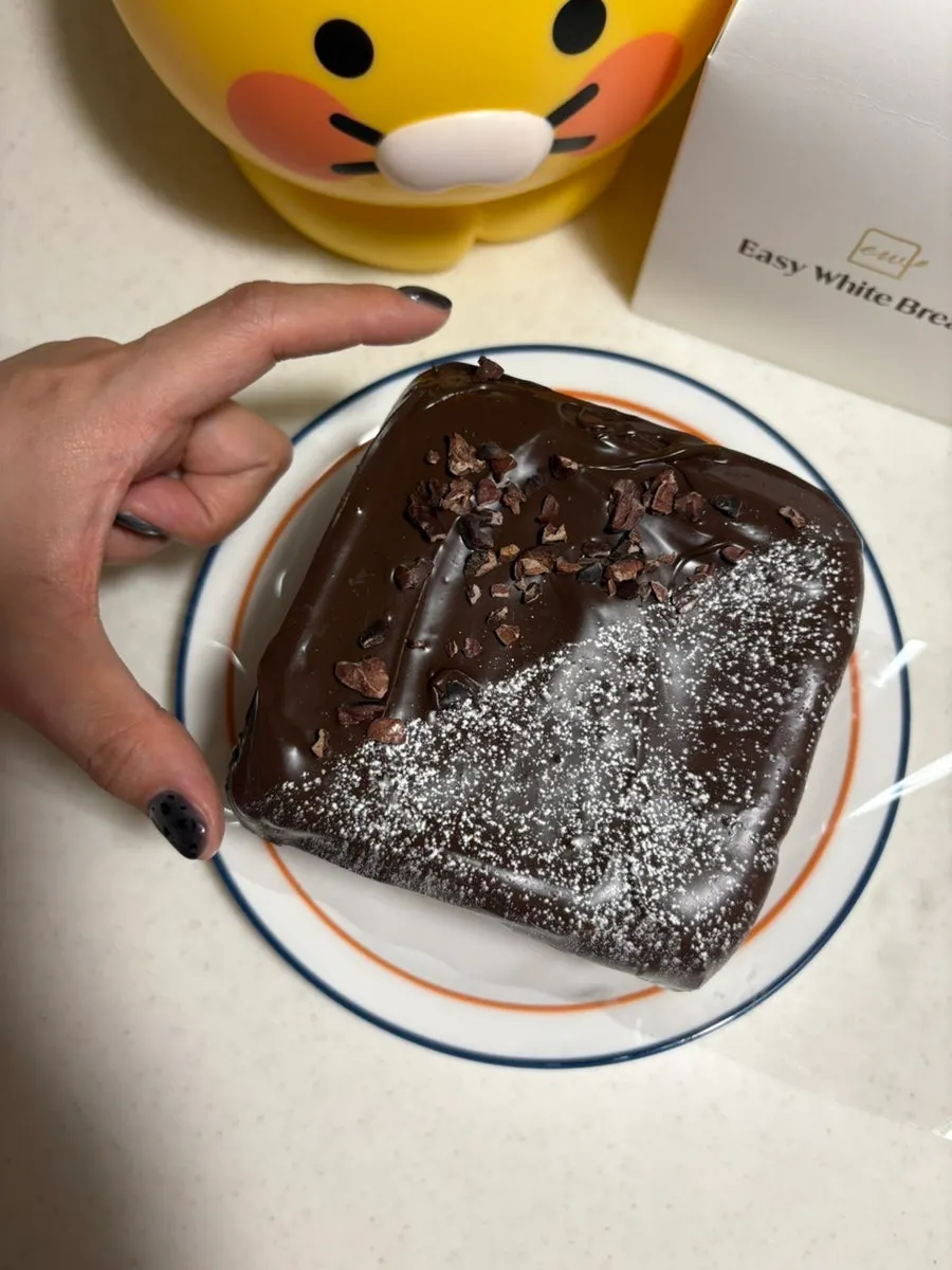 Chocolate coating dusted with sugar powder and cacao nib crumbs