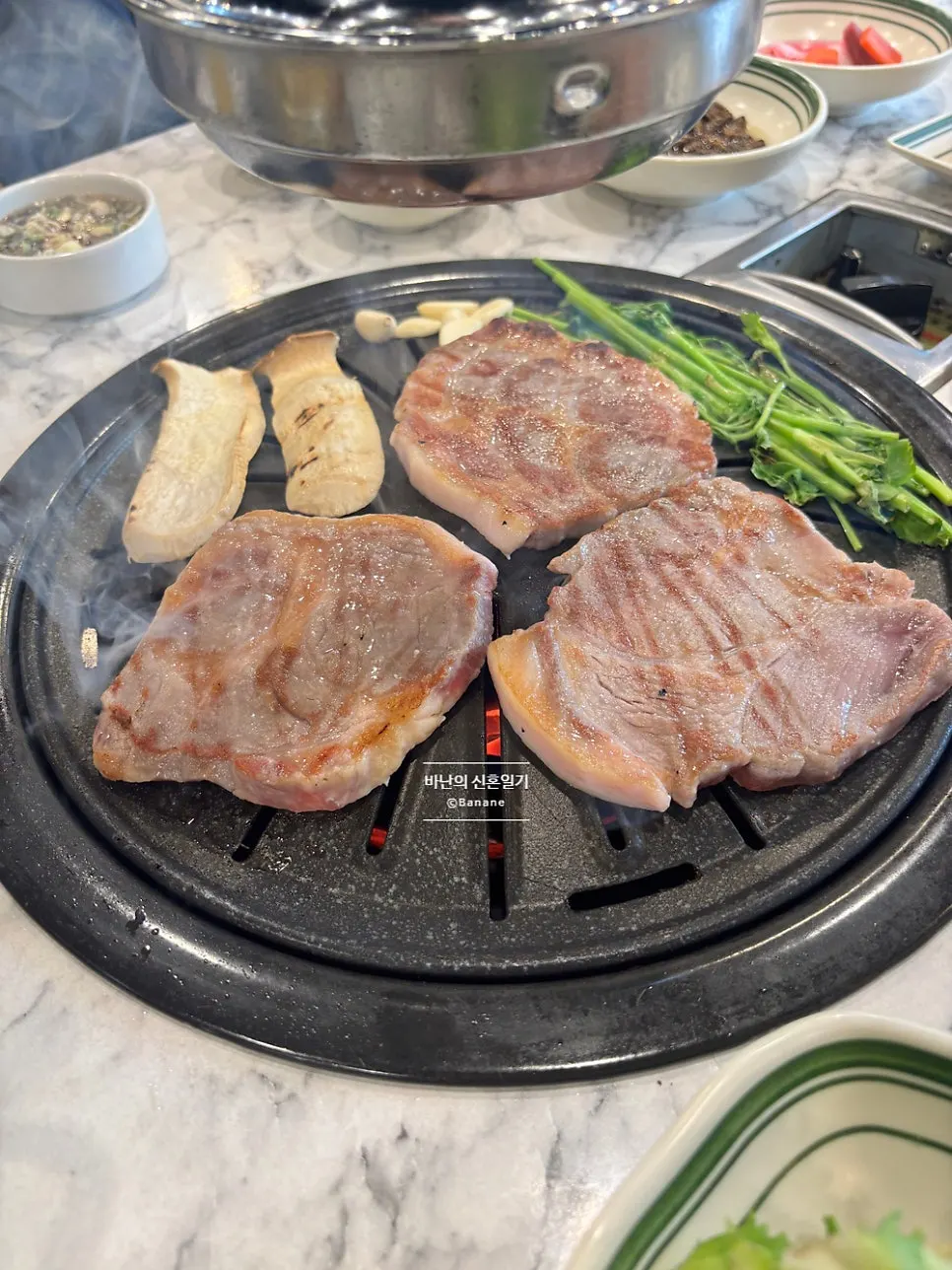 Pork belly grilling on the charcoal plate
