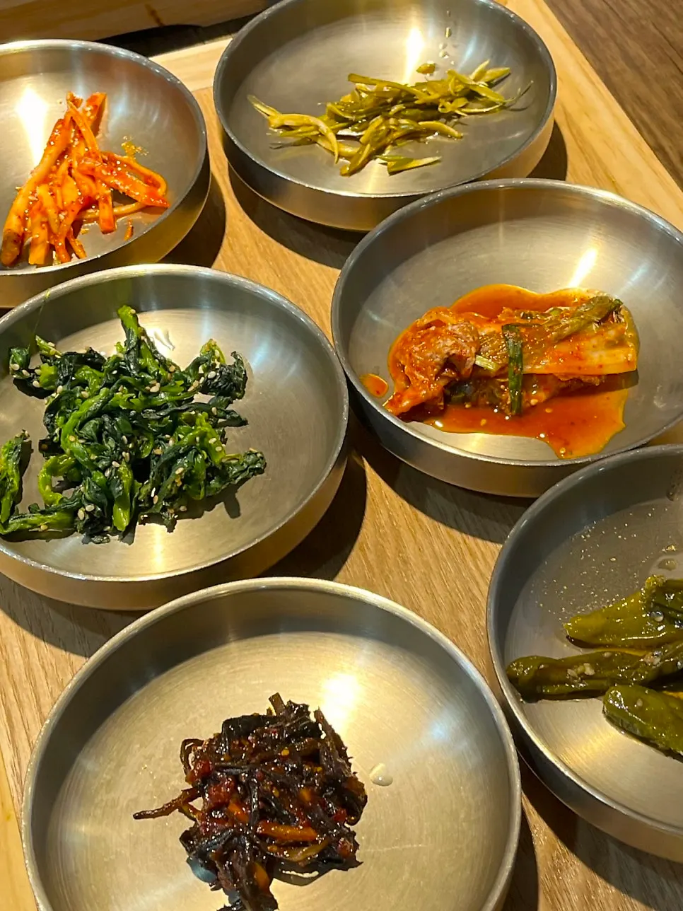 Side dishes including seasoned greens at Gim Myeongju Tteuranchae Bapsang