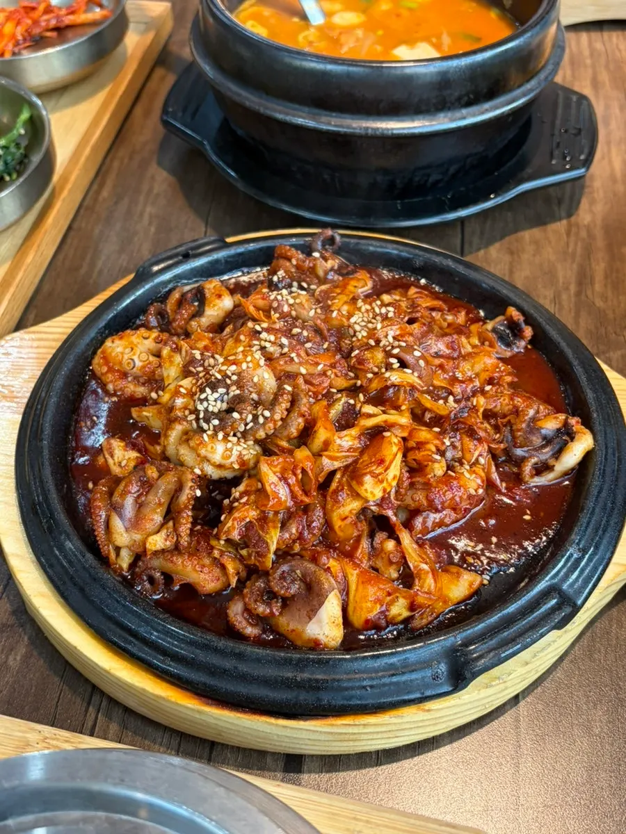 A table with octopus stir-fry, pot rice, and cheonggukjang together
