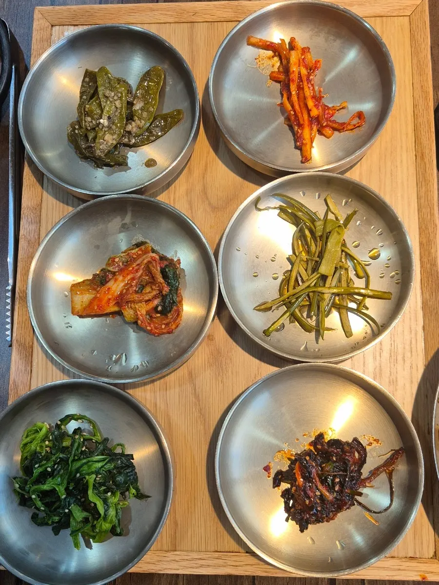 Table spread of side dishes, cheonggukjang, and soy marinated crab