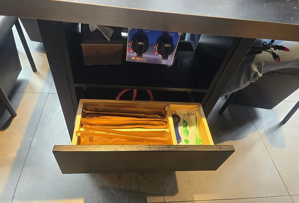 A table drawer holding utensils and wet wipes