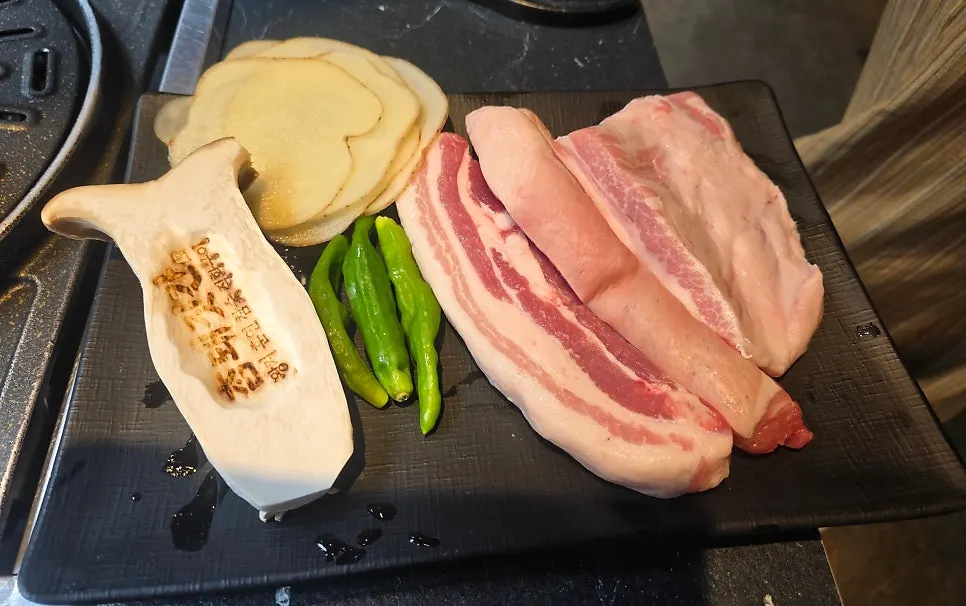 Raw cuts of black pork belly, pork belly, and pork neck