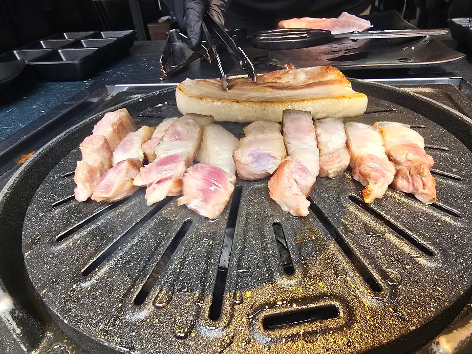 Staff grilling pork belly and vegetables
