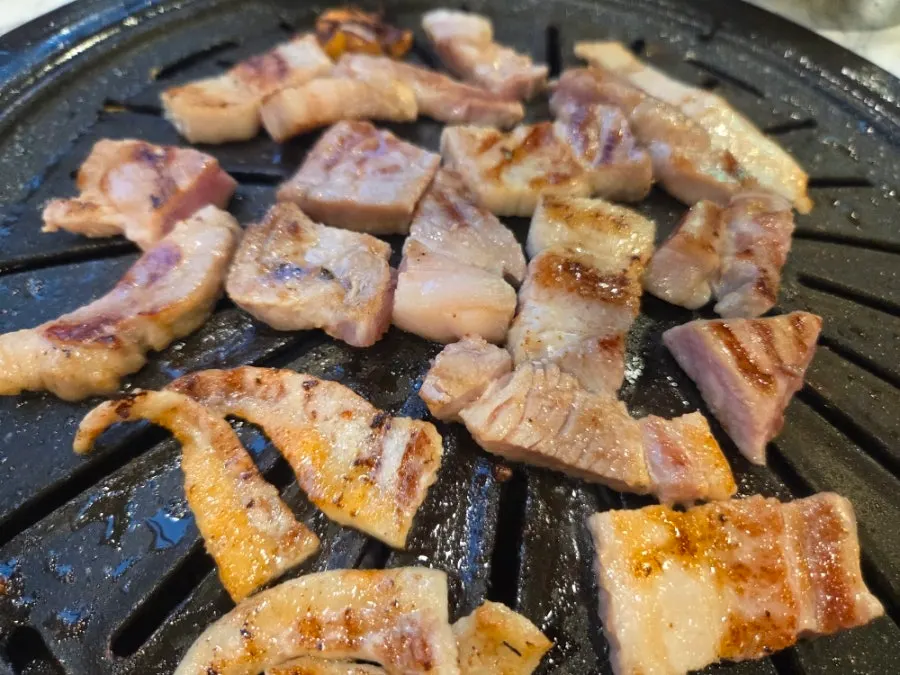 Meat plate topped with mushrooms and minari