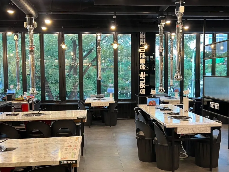 Window-side seats with a view of trees through the folding doors