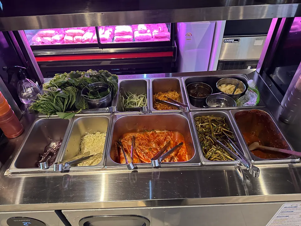 Self-serve bar with vegetable side dishes and sauces