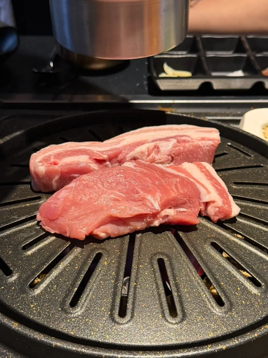 Pork belly grilling on the cauldron-lid grill plate