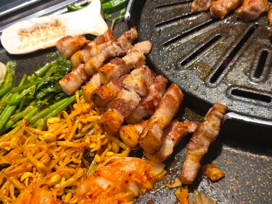 Grilled pork belly set out with accompanying side dishes
