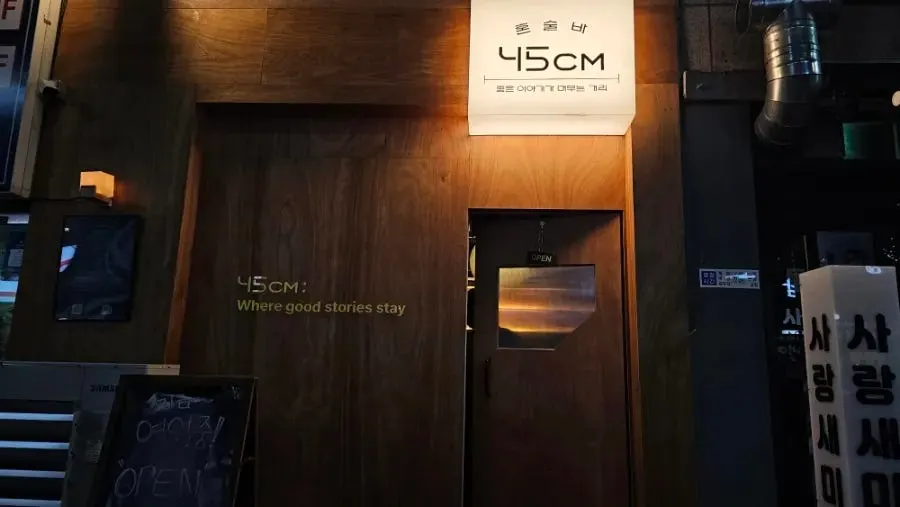 Wood-finished entrance on a night alley