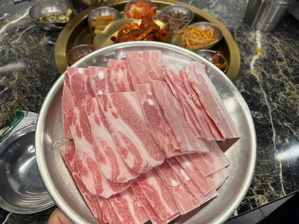접시에 가득 담긴 얇은 냉동 삼겹살
