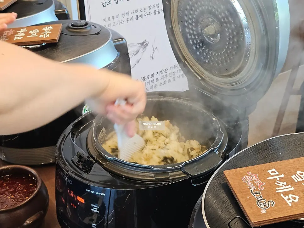 Staff member stirring freshly made gondre rice