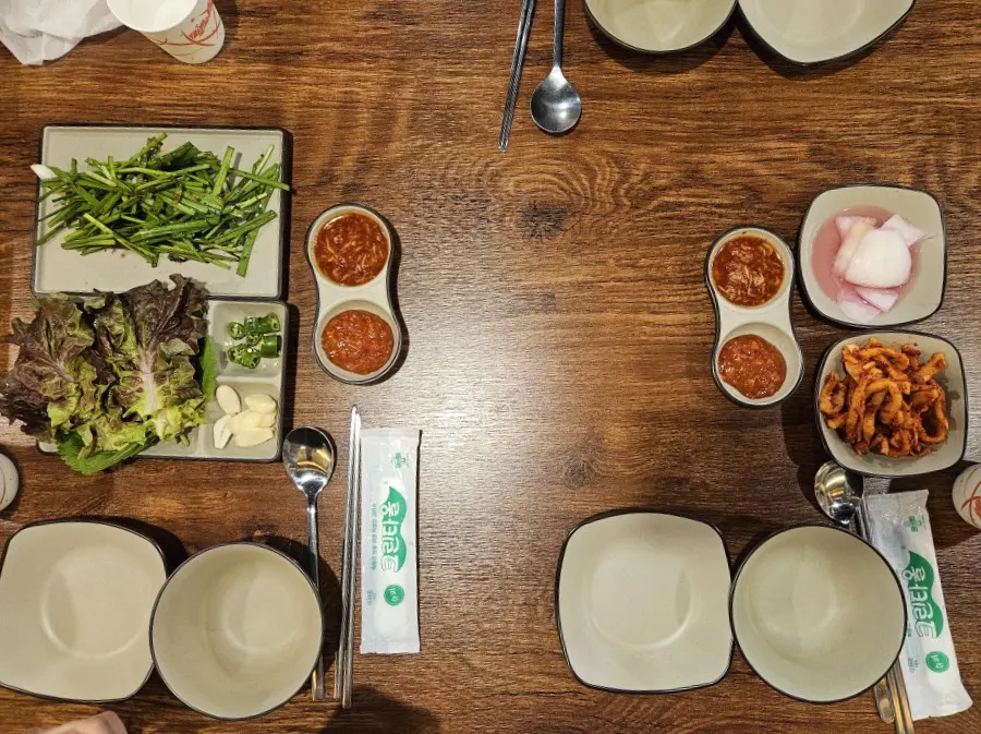 A spread of basic side dishes including vegetable wraps and chive salad