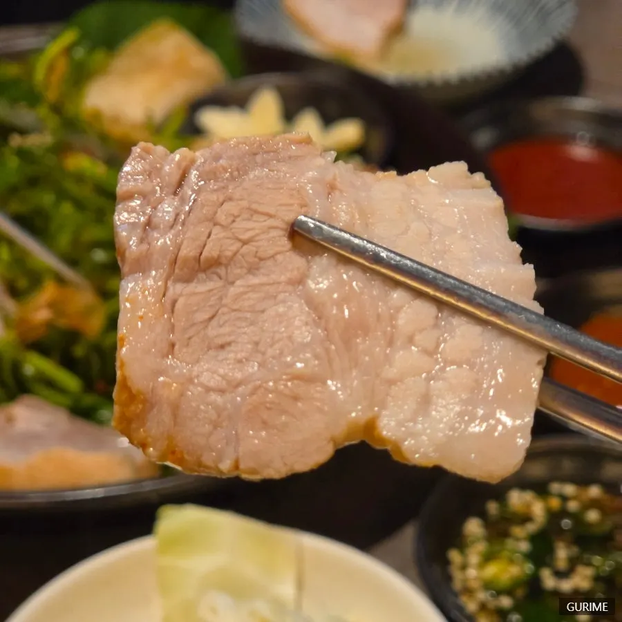 Picking up a piece of bossam pork