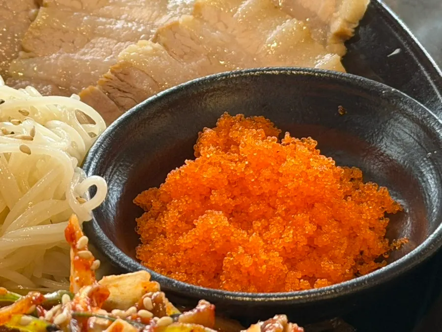 Flying fish roe and white kimchi served alongside the bossam