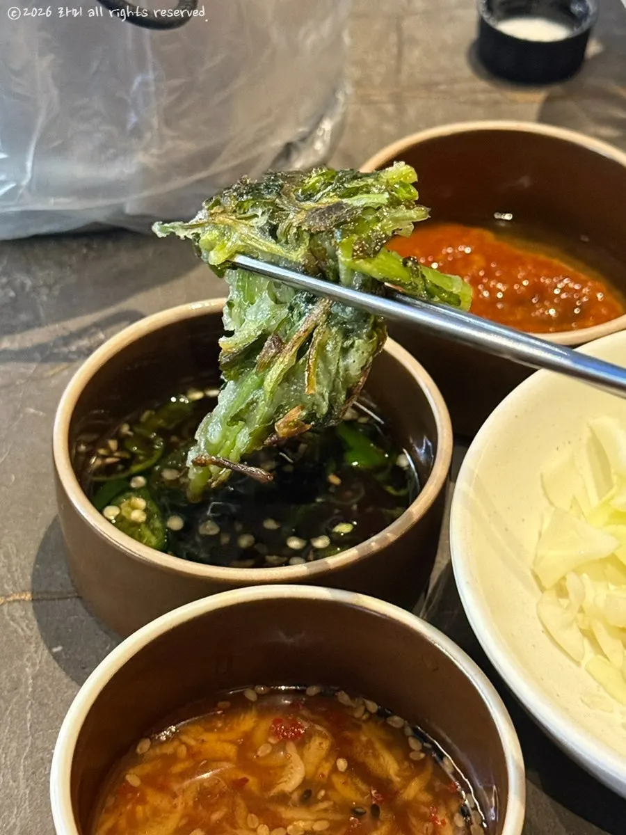 간장 소스에 찍은 미나리전 한 조각