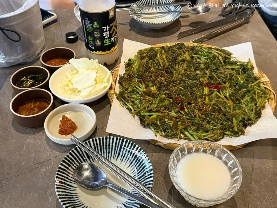 안주와 함께 놓인 시원한 막걸리 잔