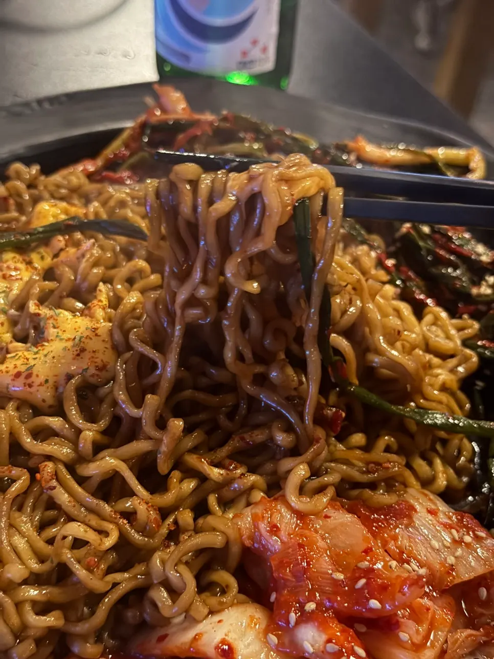 A bite of jjapaguri topped with green onion kimchi