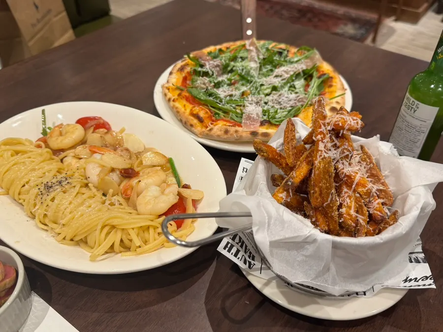 Full spread of sweet potato fries, pizza, and pasta