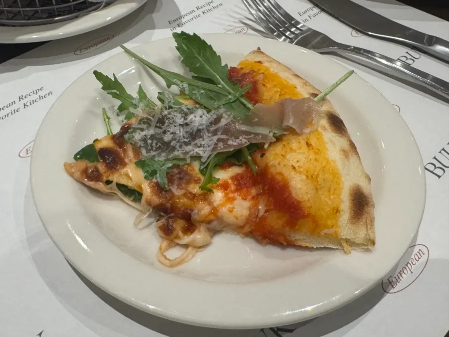 Pizza topped with rucola and prosciutto