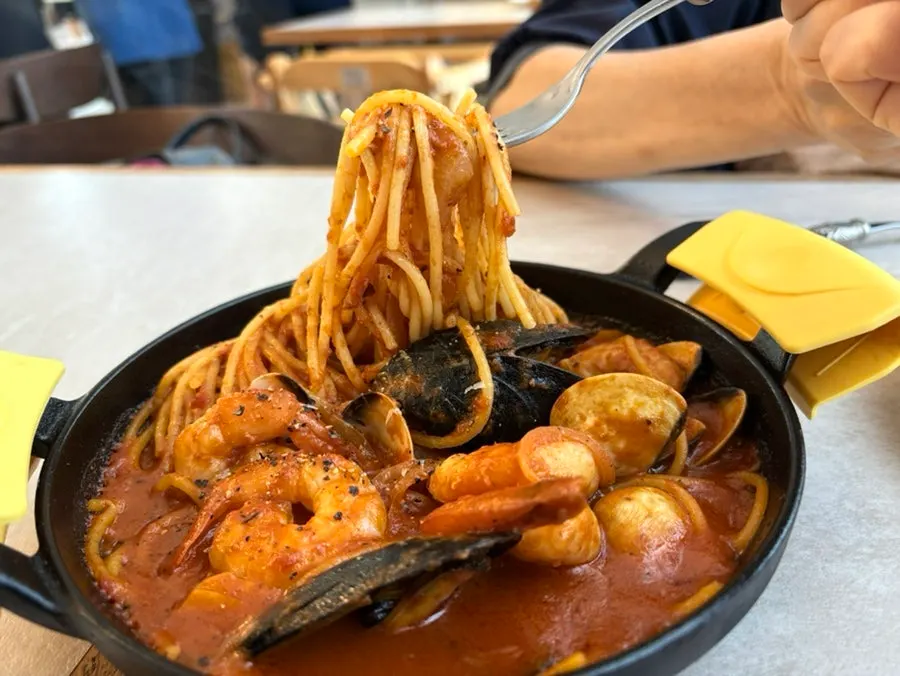 A plate of seafood tomato pasta loaded with seafood