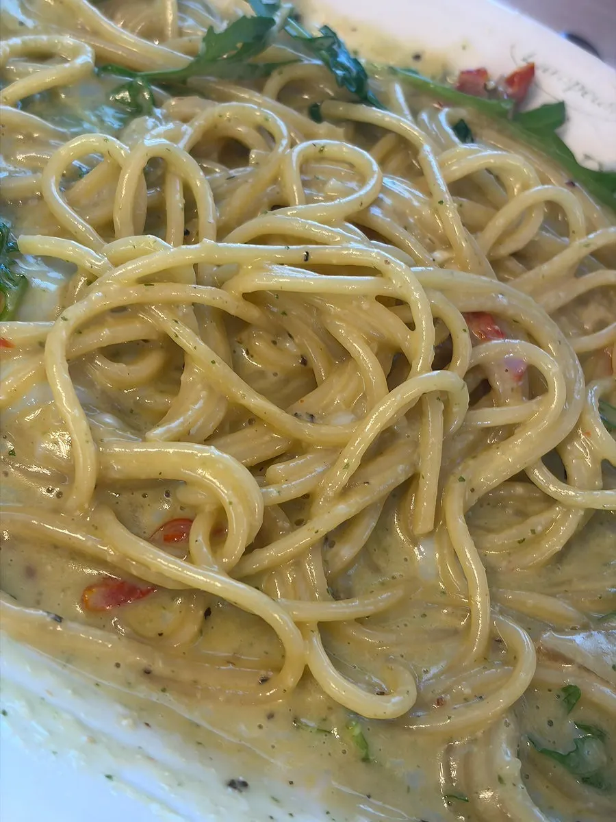Basil pesto cream pasta with the poached egg burst and mixed in