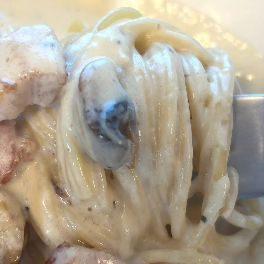 Carbonara cream pasta topped with a poached egg
