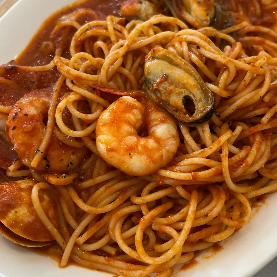 Noodles coated in rich tomato sauce, seafood pasta