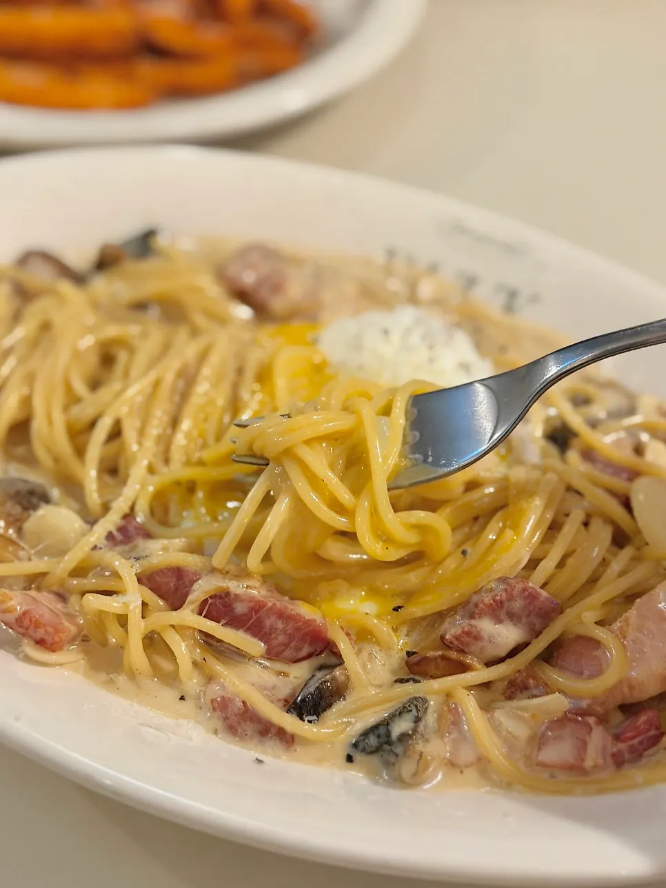 Carbonara mixed together after popping the poached egg