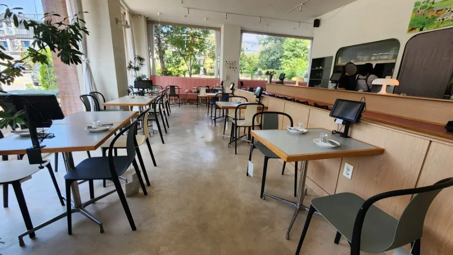 Hall with floor-to-ceiling windows and widely spaced tables