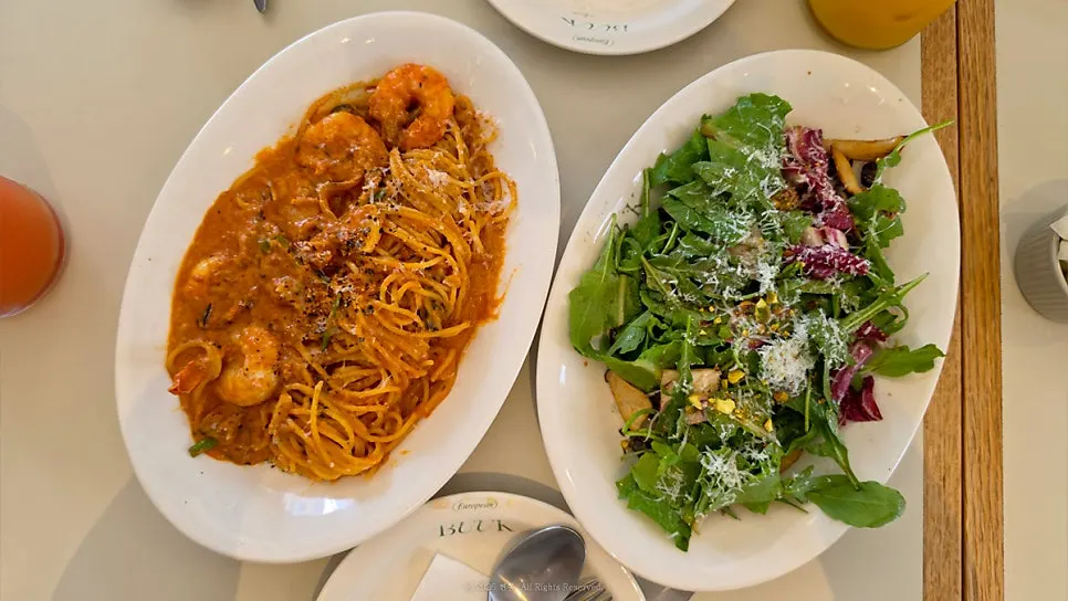 Table setting with shrimp rosé pasta and mushroom grilled salad
