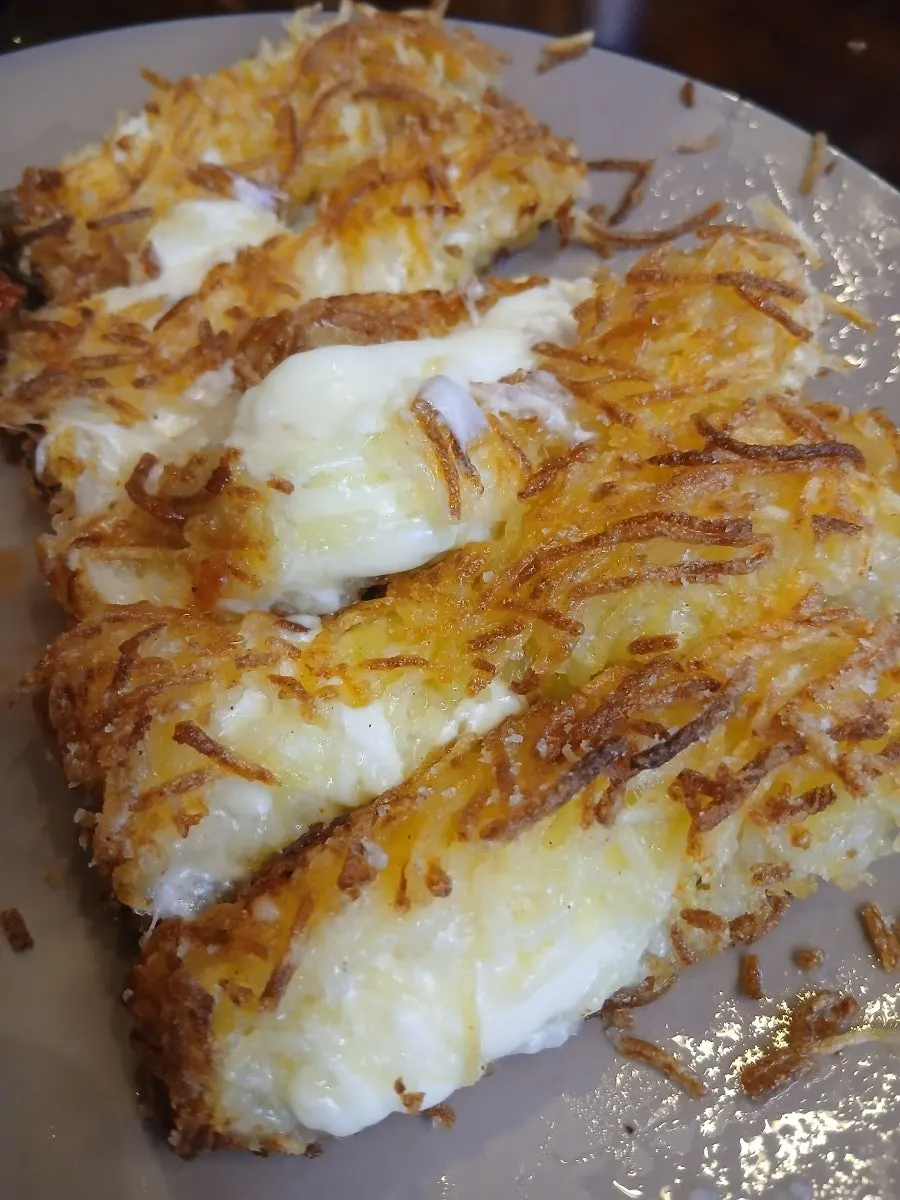 Tongs and large scissors provided for the cheese potato pancake