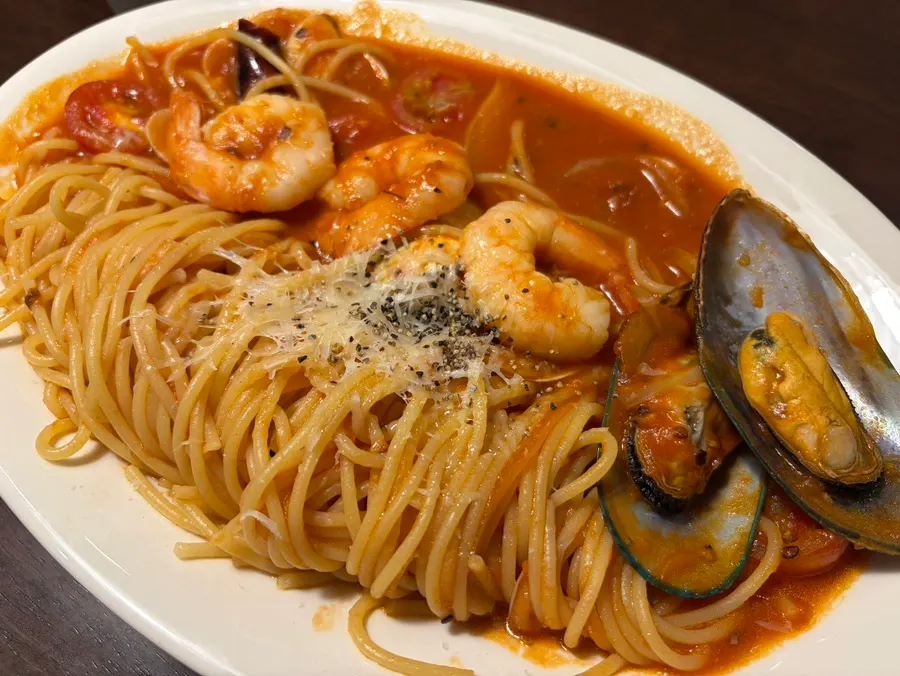 Plate of tomato pasta topped with seafood