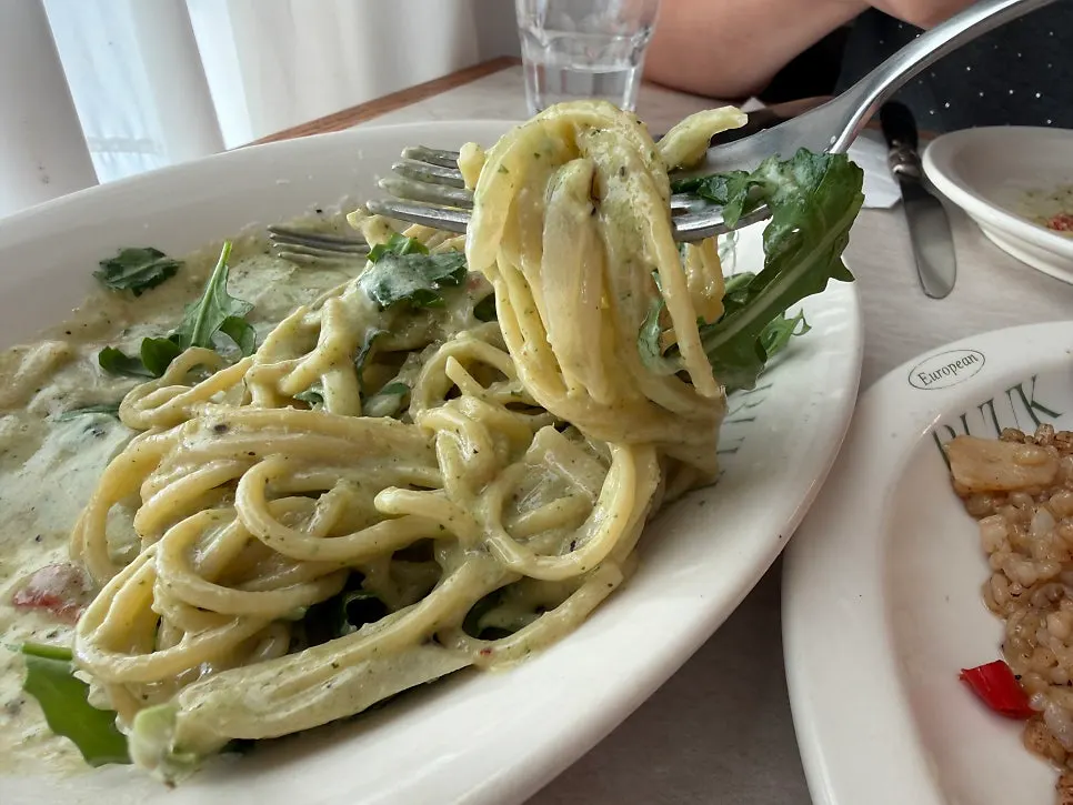 Close-up of the basil cream pasta topped with arugula