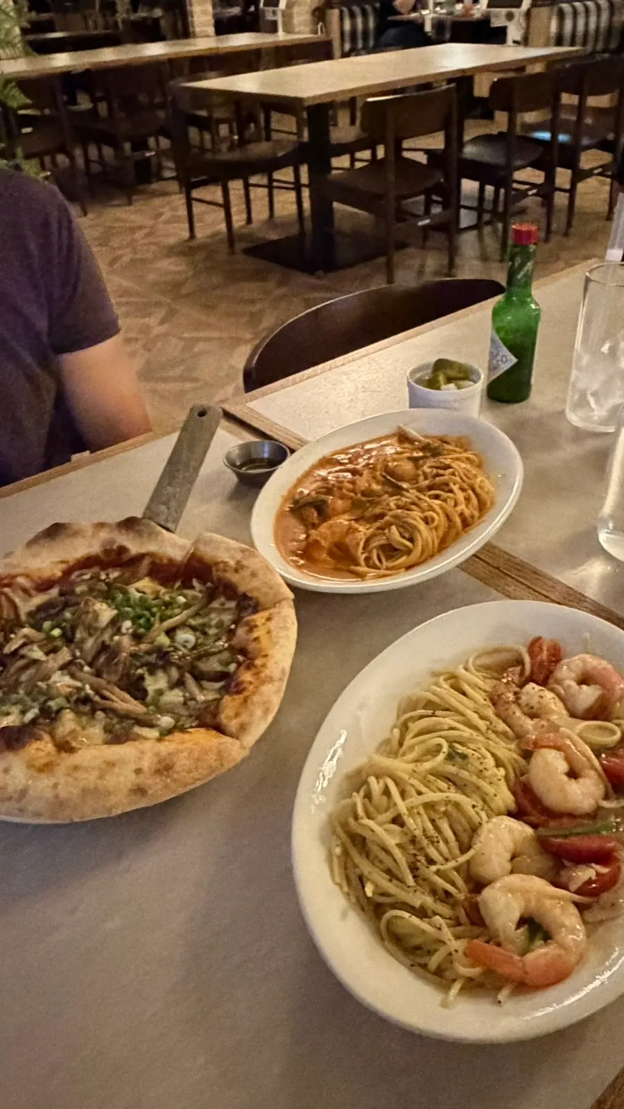 Table set with two types of pasta and a pizza
