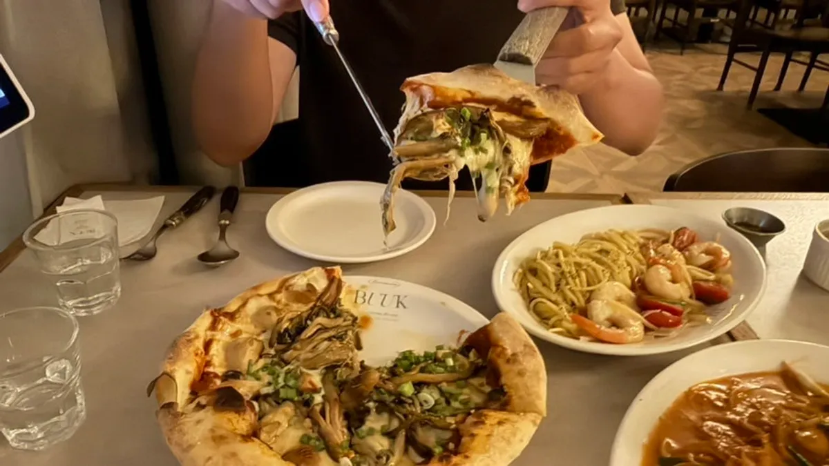 A slice of truffle mushroom pizza being lifted up