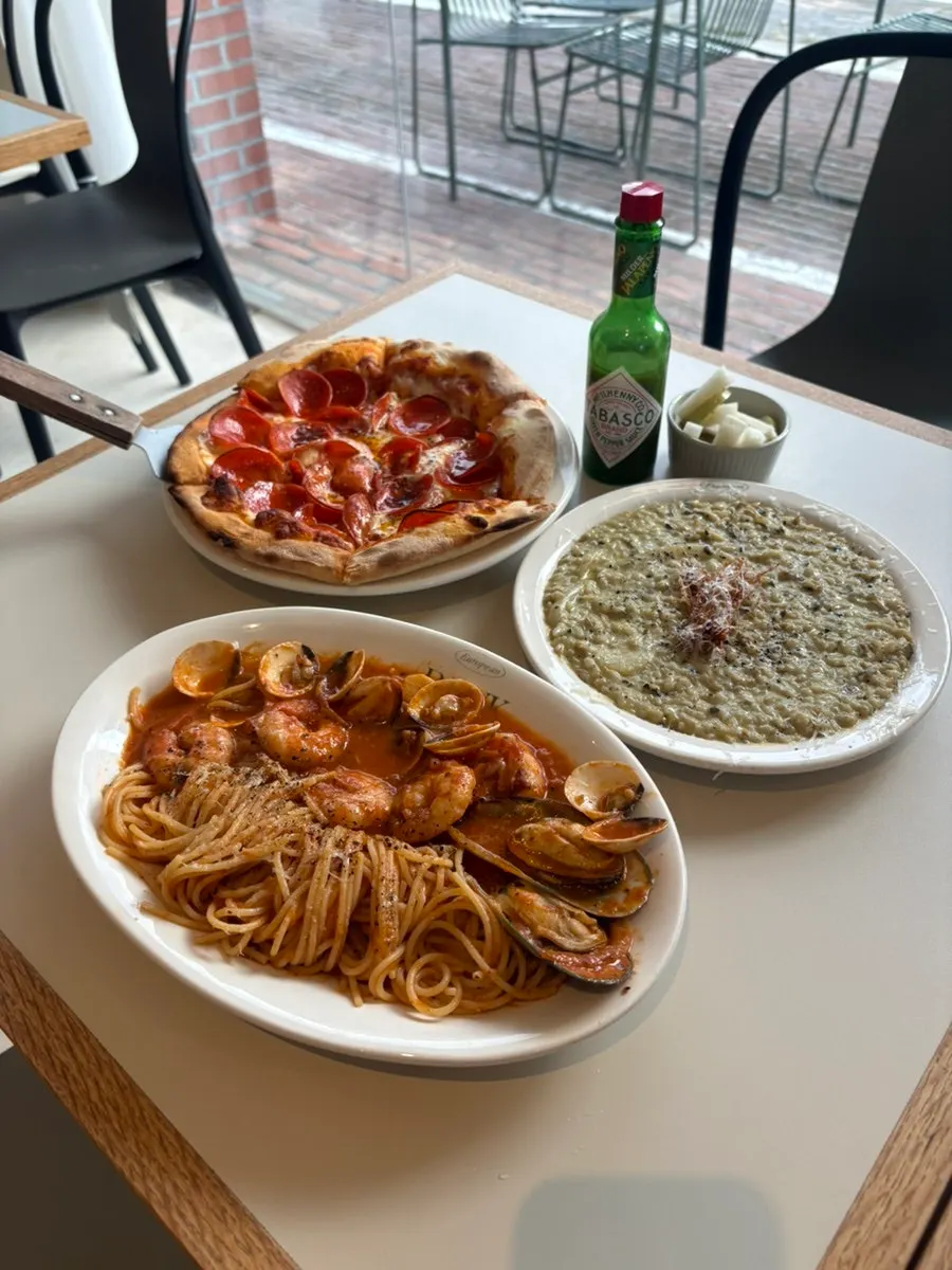 Pasta, risotto, and pizza served together on the table