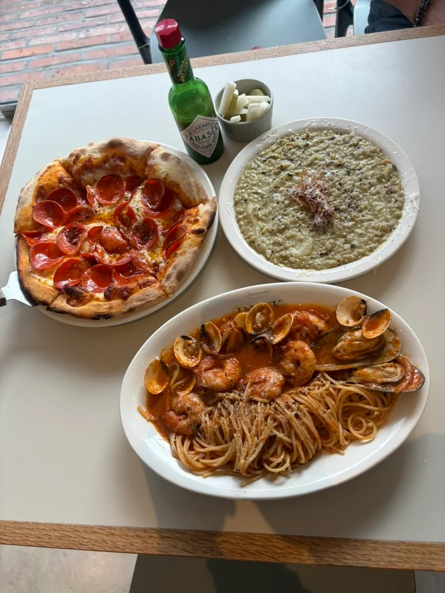 Close-up of pasta and wood-fired pizza