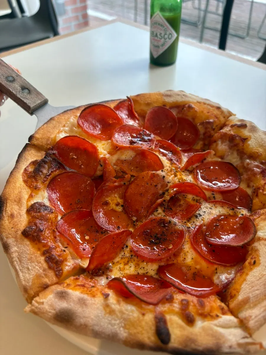 Wood-fired pizza topped with mozzarella and pepperoni