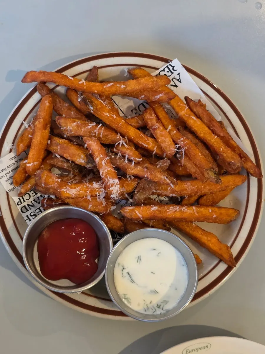 A piece of sweet potato fritter dipped in sauce