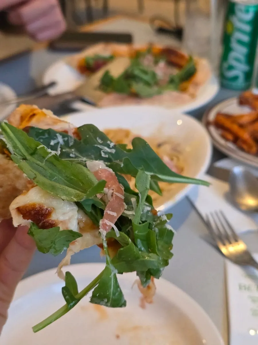 Close-up of a slice of arugula pizza
