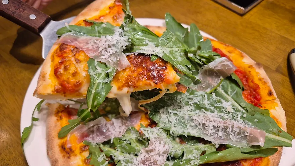 Prosciutto pizza topped with rocket and jamón