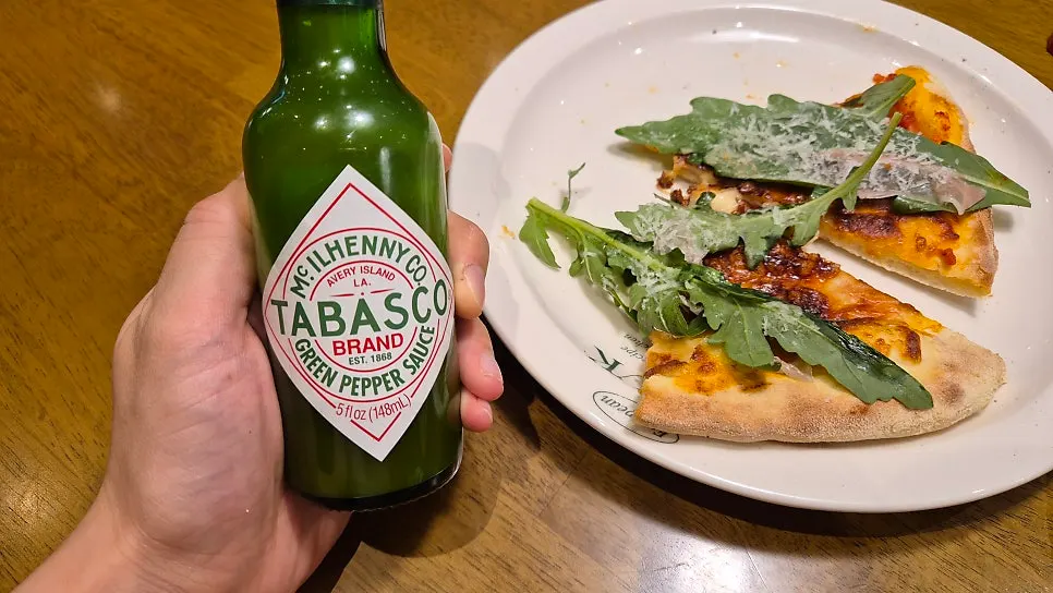 A cheesy stretch from a slice of prosciutto pizza