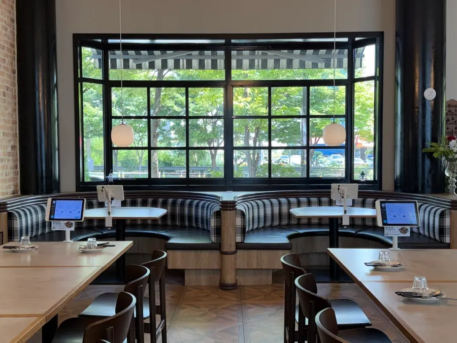 A seat with green trees visible through the window