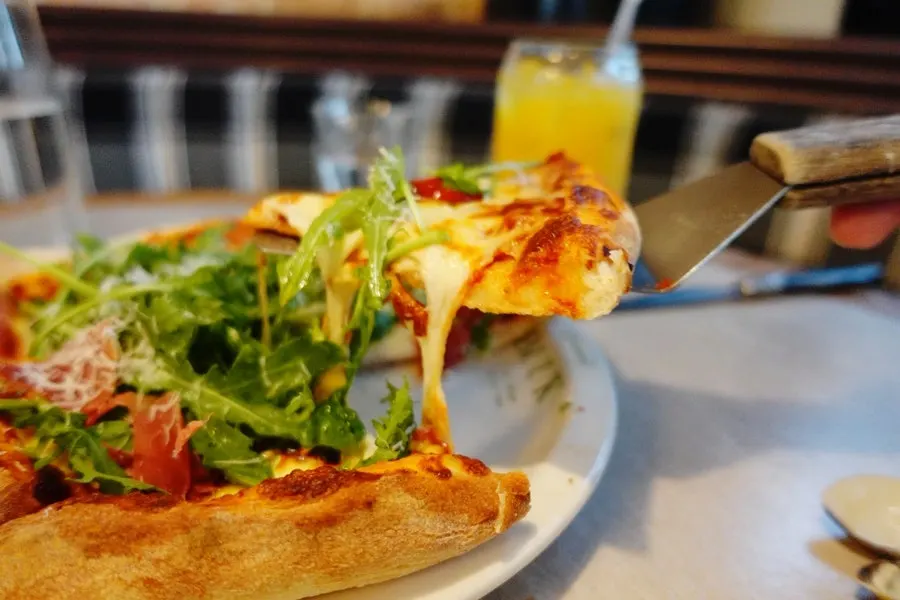 A slice of the rocket prosciutto pizza