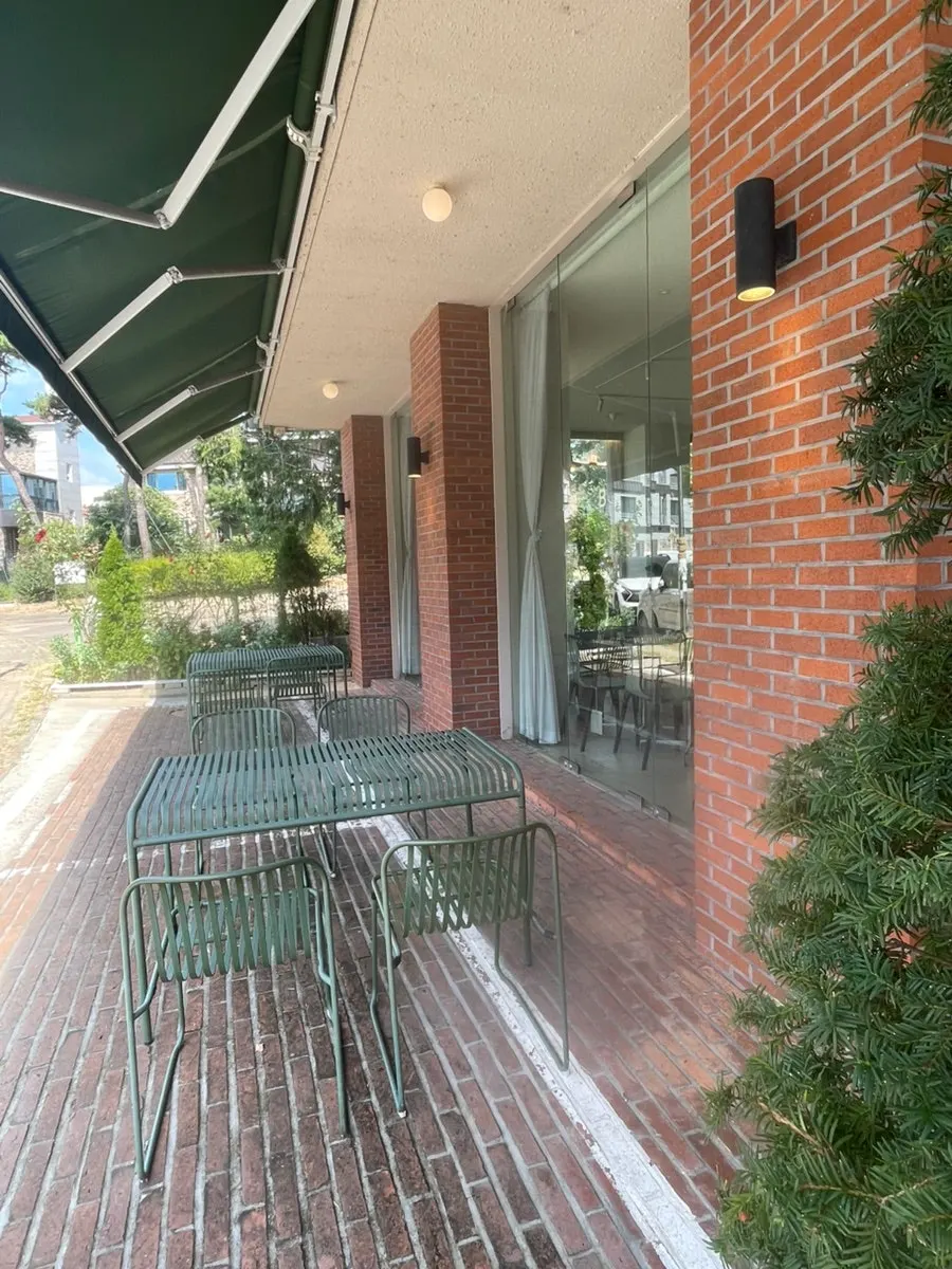 Outdoor tables and standing sign in front of the restaurant
