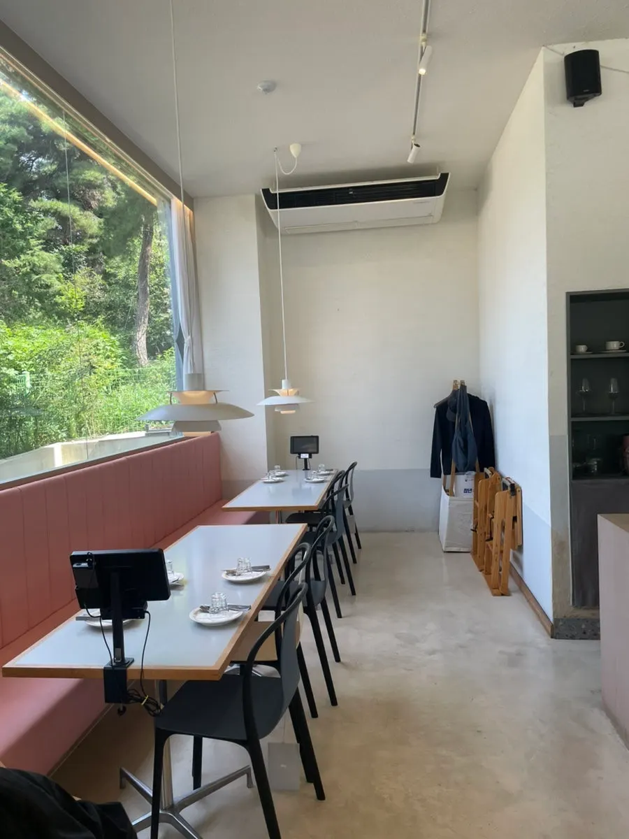 Bright dining hall with trees visible through the window