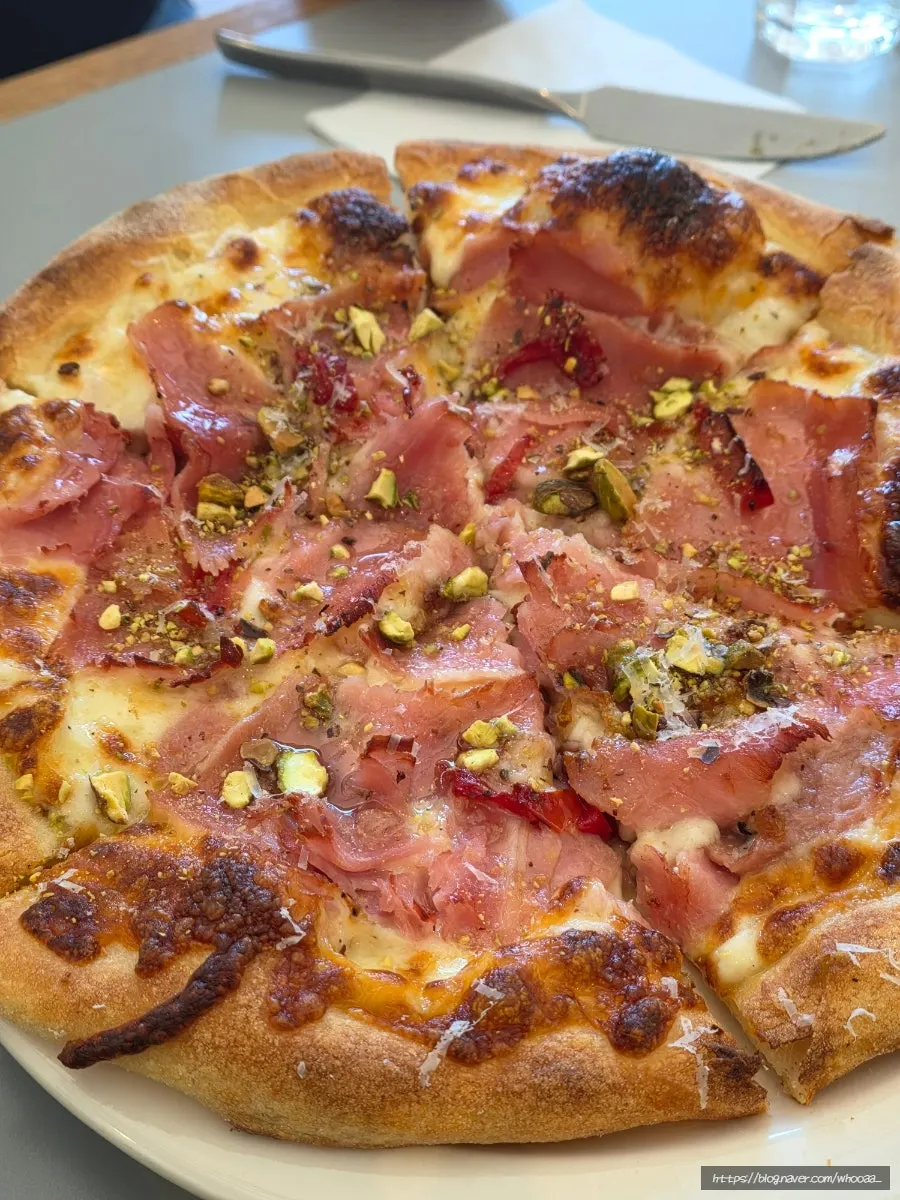Jambon pizza topped with honey and pistachios